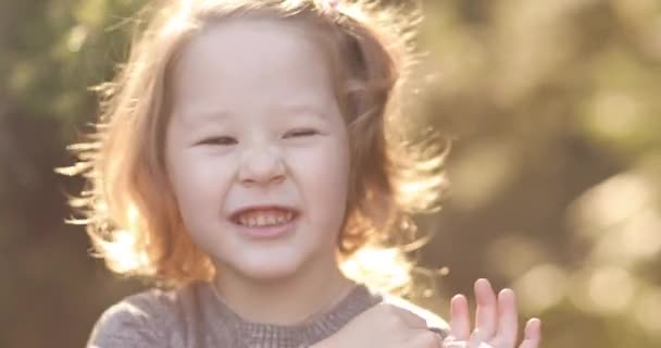 Klein kind spelen in mooie zonnige maar koude dag buiten. — Stockvideo