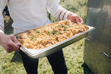 Büyük bir pilav kabı olan adam.