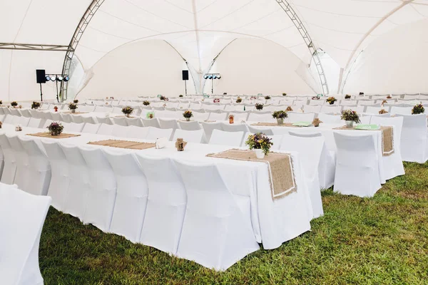 Catering with white long tables and chairs.