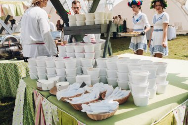 Masada kaplarda çorba. Yeşil masa örtüsü ile masada paket servis için hazırlanan kırmızı çorba veya borsch beyaz plastik kapyığınları.