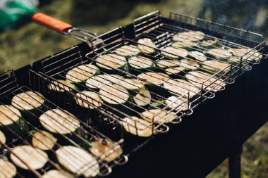 Izgara üzerine lahana. Açık hava ızgara ekipmanlarında ızgara olan çiğ dilimlenmiş kabak yakın çekim.