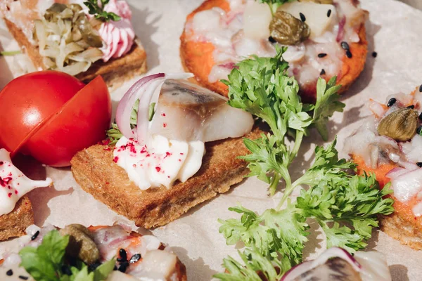 Ringa balığı ile lezzetli kanepeler. Taze ringa balığı, siyah susam, gevrek ekmek üzerine krem peynir ile lezzetli kanape veya sandviç Makro.