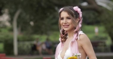 Çiçekleri koklayan kanekalonlu güzel kız.