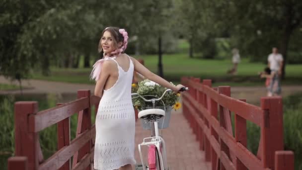 Romantikus szexi lány fehér nyári ruha séta a kerékpár-fa híd erdei Park