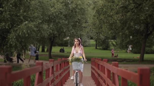 Lovely woman with kanekalons riding a bicycle. — Stock Video