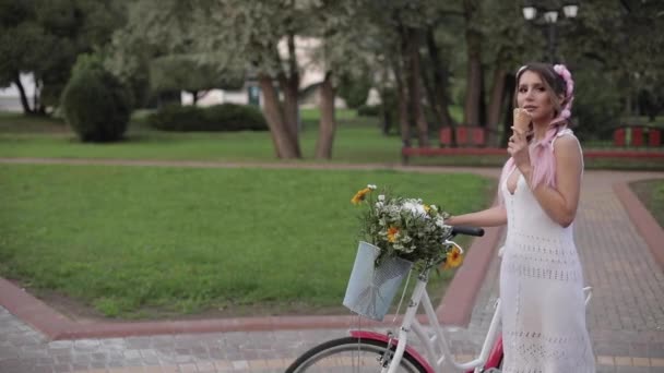 걷는 동안 아이스크림을 먹는 두 머리띠와 예쁜 소녀 — 비디오