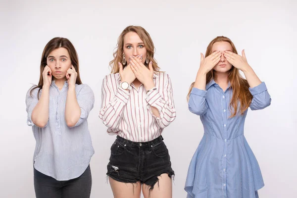 Trois jeune amie posant avec les yeux fermés oreilles et la bouche en regardant la caméra plan moyen — Photo