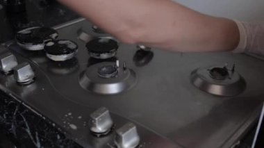 Yakın çekim kadın el giyen eldiven temizliği mutfak sobayı sünger kullanarak