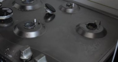 Yakın çekim kadın el giyen eldiven temizliği mutfak sobayı sünger kullanarak