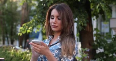 Açık hava kafede mobil tarama Mutlu güzel kadın.