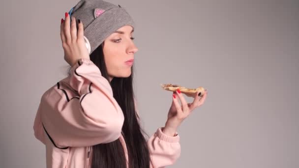 Ung kaukasisk kvinna med svans äta bit pizza. — Stockvideo