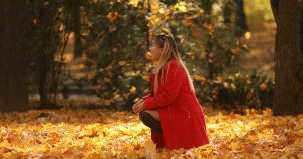 Donna bionda in cappotto rosso che saluta la figlia nel parco autunnale . — Video Stock