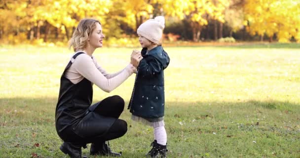 Liebevolle glückliche Mutter mit ihrer Tochter im herbstlichen Park. — Stockvideo