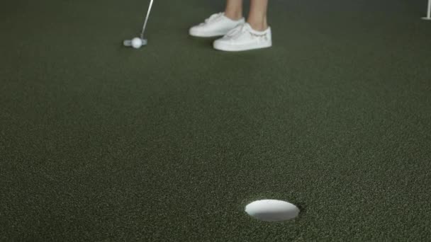 Обрезанный вид мяча для гольфа, попадающего в хейл в синтетической траве — стоковое видео