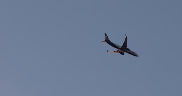 Летающий авиатранспорт в окружении ясного голубого неба в летний день экстремально длинный выстрел — стоковое видео