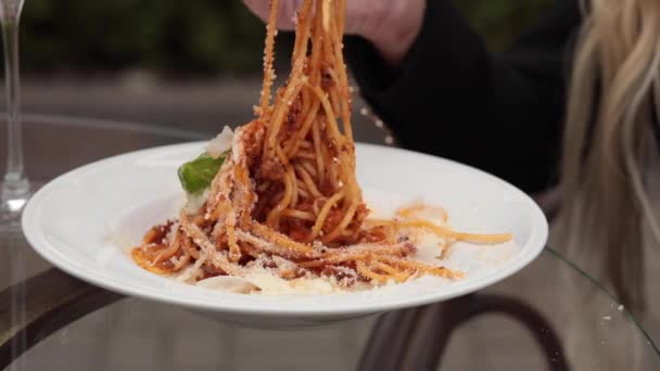 Gros plan attrayant main féminine mangeant des pâtes fraîches savoureuses de grande assiette blanche à l'aide d'une fourchette — Video