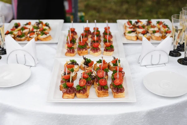 Delicious toasts served on white plates at wedding reception. — Stock Photo, Image