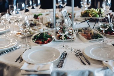 Atıştırmalık ve boş şarap kadehleriyle servis edilen masa..