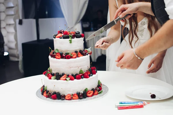 Grote geweldige bruiloft smakelijke taart met witte slagroom bedekt met verse sappige bessen en fruit — Stockfoto