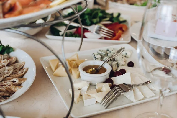Krájený sýrový talíř s medem a hroznem. — Stock fotografie