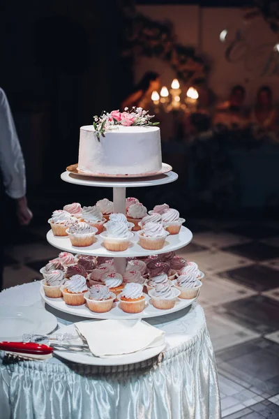 Gyönyörű esküvői torta virágokkal az asztalon — Stock Fotó