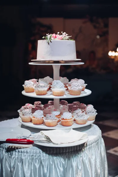 Krásný svatební dort s květinami na stole — Stock fotografie