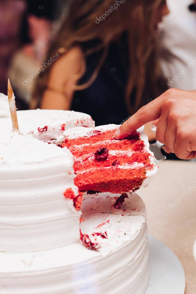 Person taking a slice of red velvet cake.
