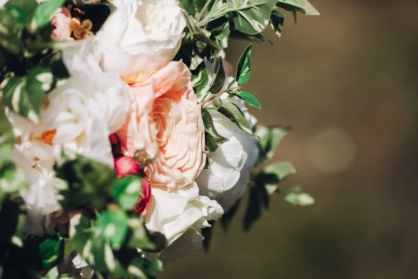 Close-up of flowers in sunlight.Close-up of roses and greenery wedding decor in sunlight.
