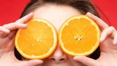 Taze portakallarla poz veren neşeli genç sarışın.