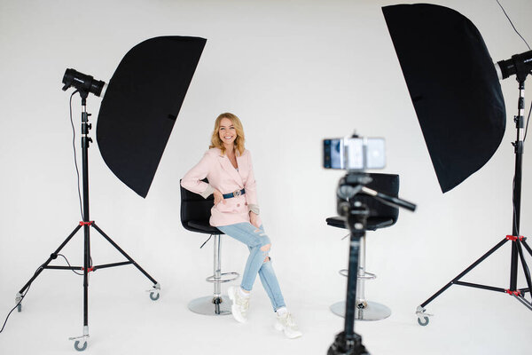 Gorgeous woman welcoming in her photo studio with equipment.