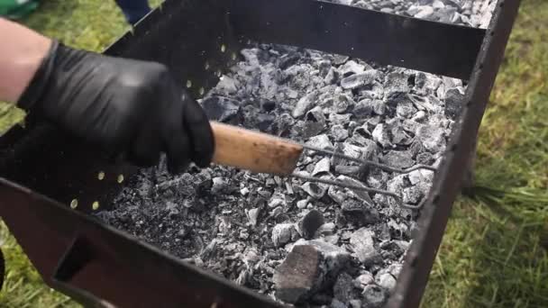 Une personne casse du charbon noir. Gros plan Vidéo de stock 4K de charbon noir dégoulinant après barbecue . — Video