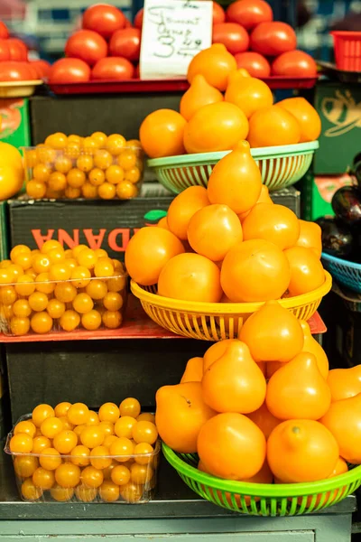 Žlutá rajčata a cherry rajčata na trhu jsou v košíku — Stock fotografie