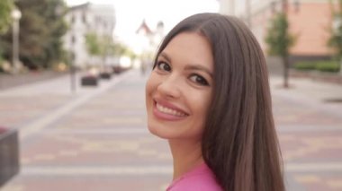 Uzun, kalın saçlı, mutlu bir kadın.