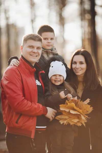 Gelukkige familie in herfstpark in zonlicht. — Stockfoto