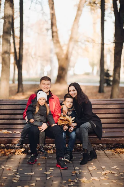 Lächelnde Eltern und Kinder auf der Bank im Freien — Stockfoto