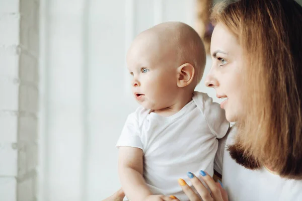 En vacker kvinna som håller sin son hemma. — Stockfoto