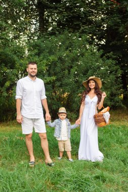 Parkta yürüyen mutlu bir aile.