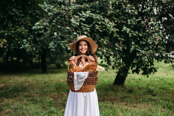 Porträt eines jungen schönen Mädchens mit sogar weißen Zähnen, einem schönen Lächeln im Strohhut beim Picknick im Garten — Stockfoto