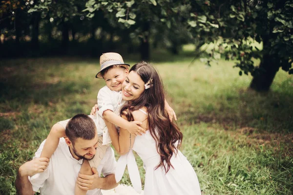 Belle maman, papa et leur mignon petit enfant s'amusent ensemble et sourit dehors — Photo