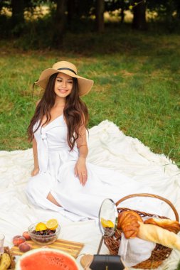 Parktaki ağacın yanında poz veren çekici genç bayan.