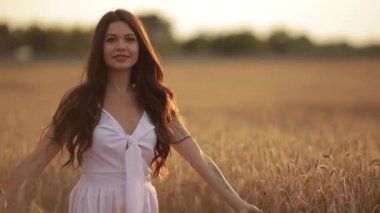 Koyu saçlı kadın tarlada dönüyor.