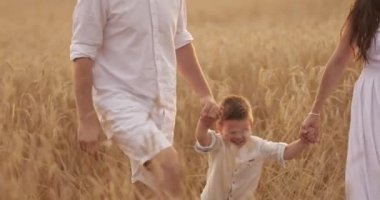 Anne ve baba oğullarını havaya kaldırıyorlar.