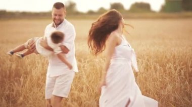 Anne ve baba oğullarını havaya kaldırıyorlar.