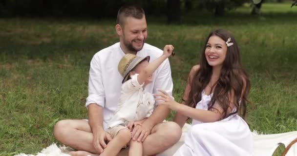 Mulher de vestido de verão beijando seu cônjuge e filho — Vídeo de Stock