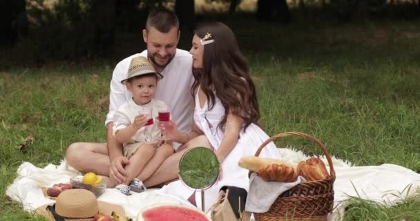 Woman in a sundress kissing her spouse and son — Stock Video