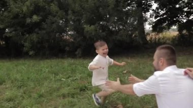 Sevgi dolu baba neşeli çocuğunu havaya kaldırıyor.