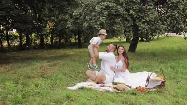 Vidéo de belle famille caucasienne avec un enfant passer beaucoup de temps ensemble et s'amuser dans le parc en été — Video