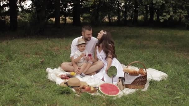 Son feeding his mother with cherry in park. — Stock Video