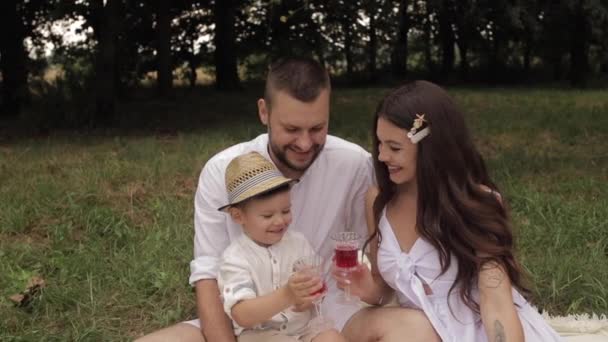 Vrolijke blanke mama, papa en hun kind hebben plezier samen en glimlacht in de tuin — Stockvideo