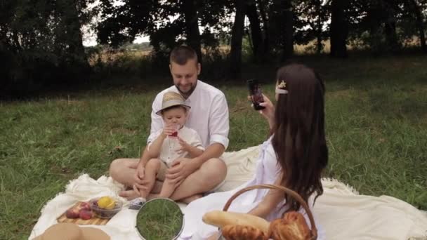 Vrouw neemt foto 's van haar echtgenoot en zoon — Stockvideo
